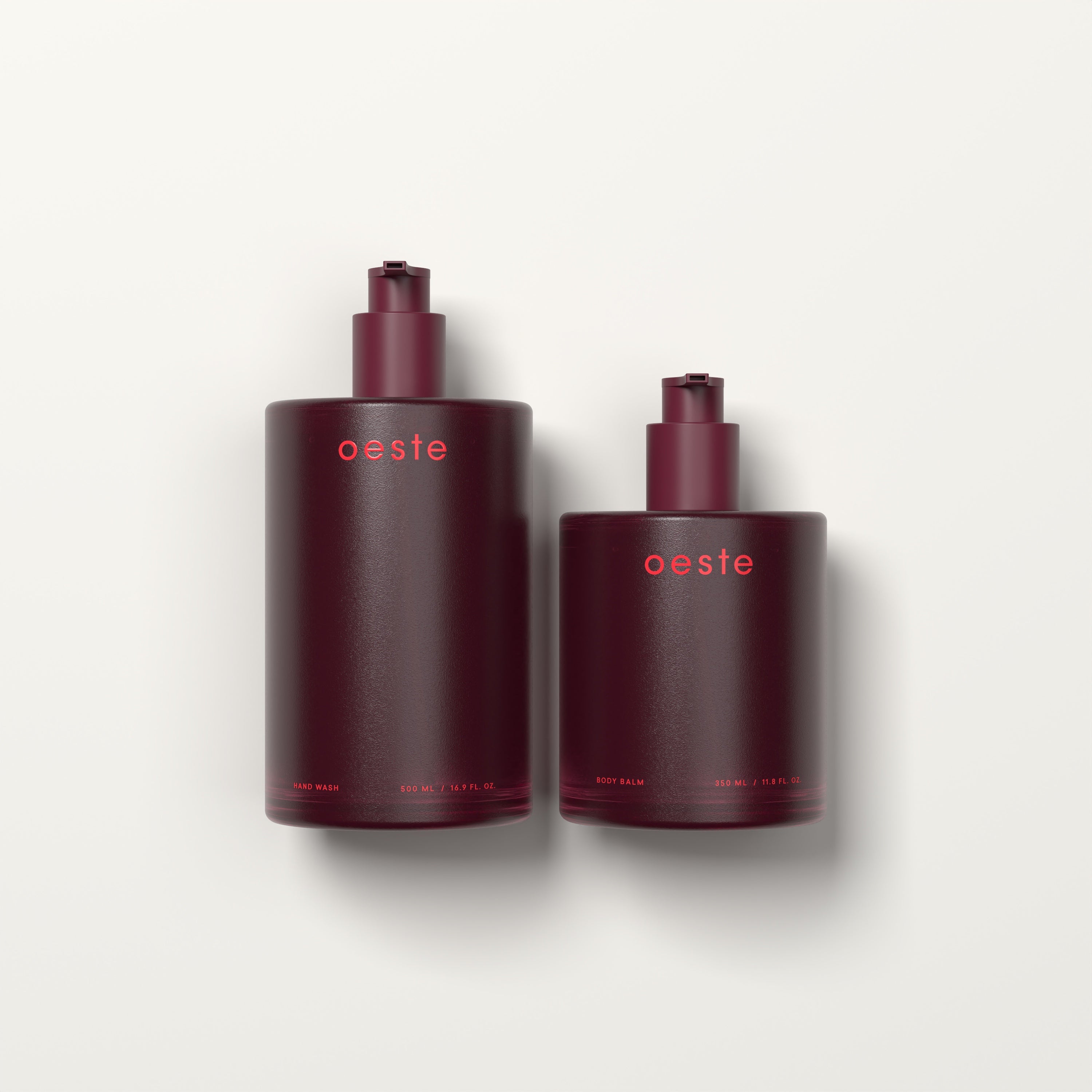 Two burgundy Oeste refillable personal care bottles